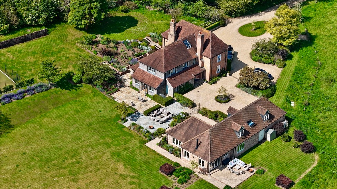 Aerial view of a country house with gravel driveway and gardens